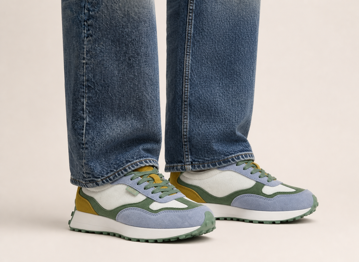 Detalle zapatillas casual unisex Kuse verde azul mostaza bajo jeans rectos estilo urbano contemporáneo