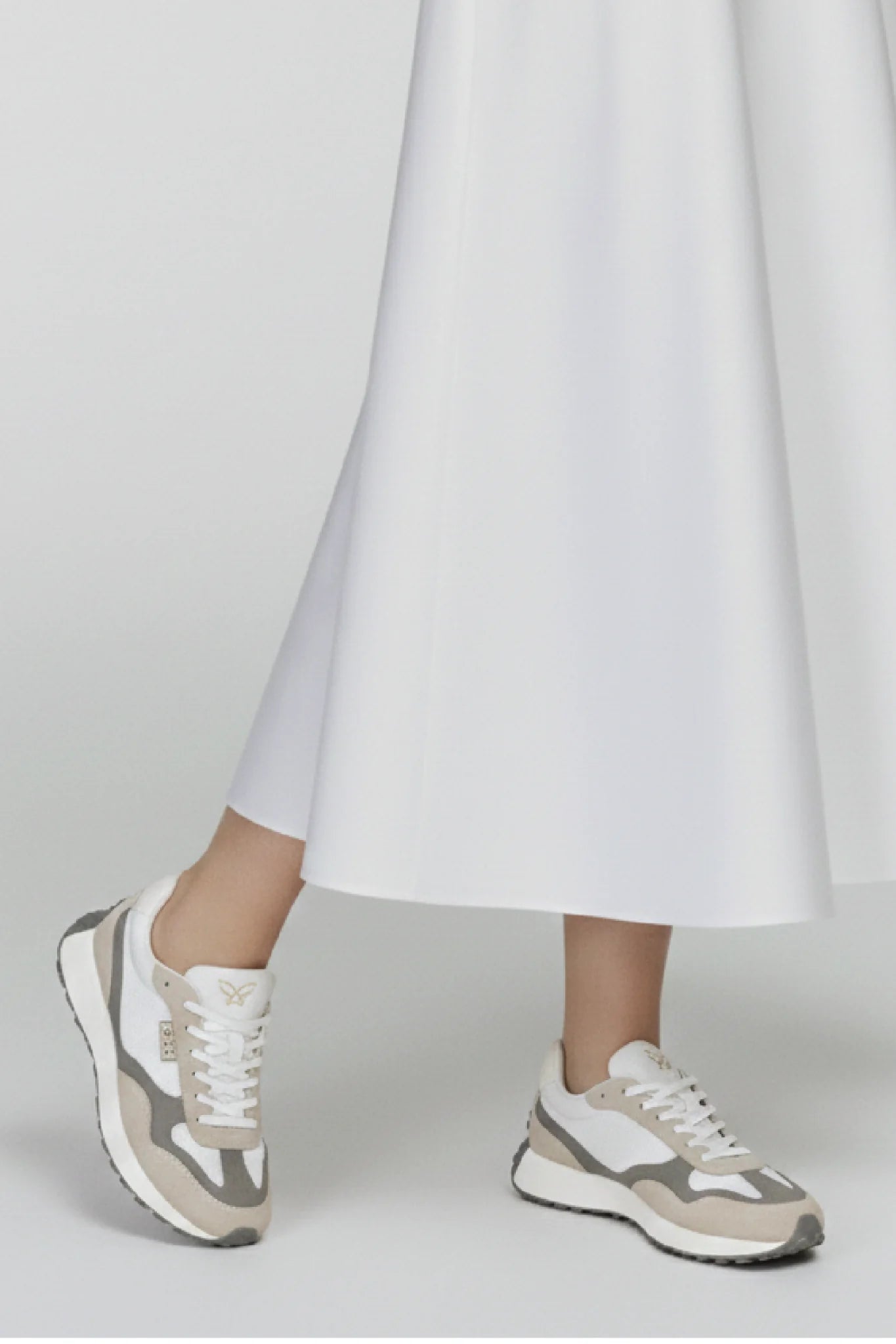 Detalle outfit femenino con zapatillas Kuse beige y gris estilo urbano minimalista