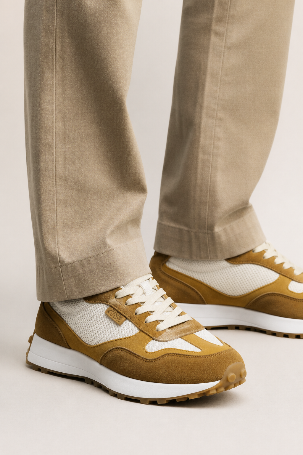 Zapatillas Kuse unisex marrones combinadas con pantalón beige, estilo casual elegante para hombre