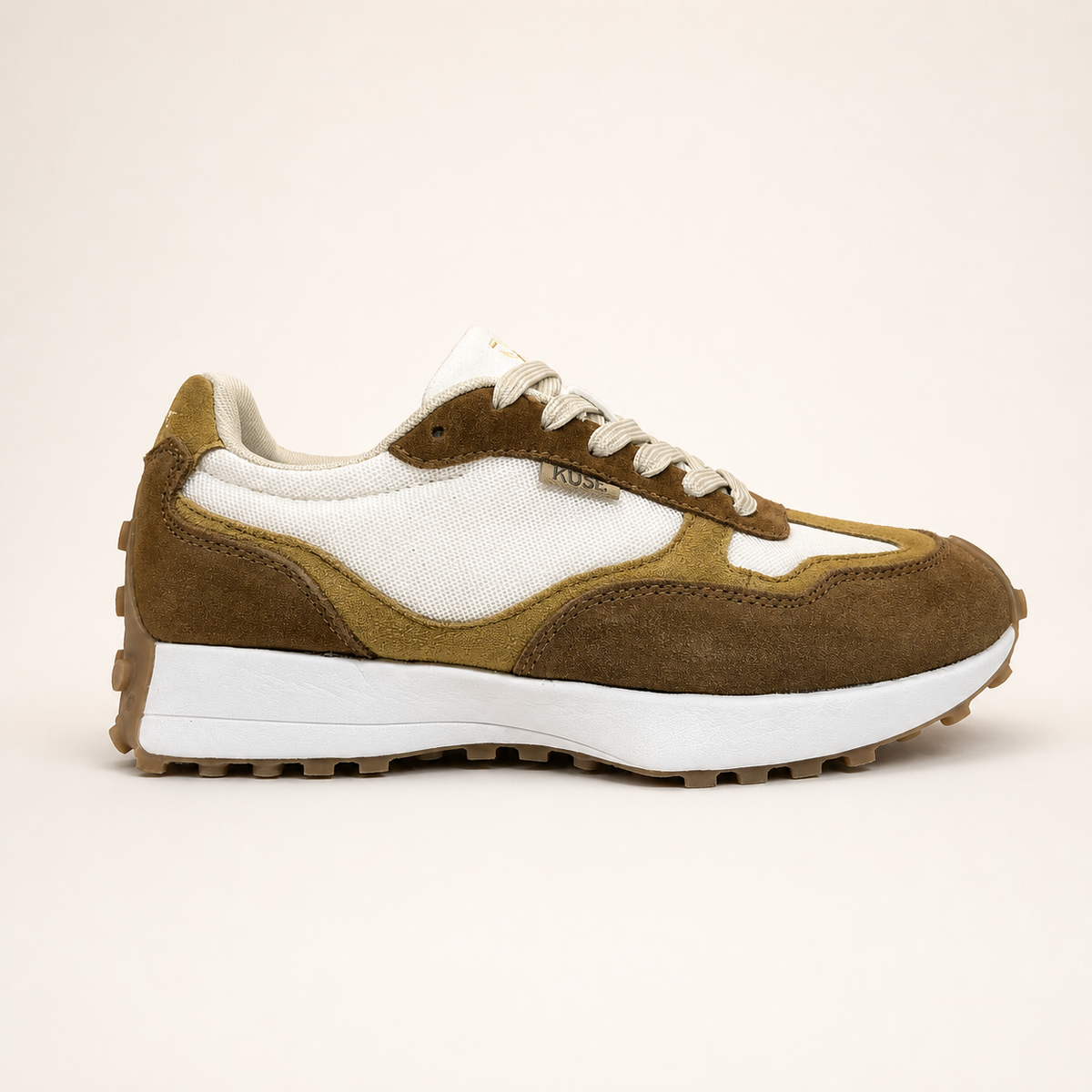 Zapatillas casual unisex Kuse tones marrones vista lateral con diseño retro, malla blanca y suela dentada beige