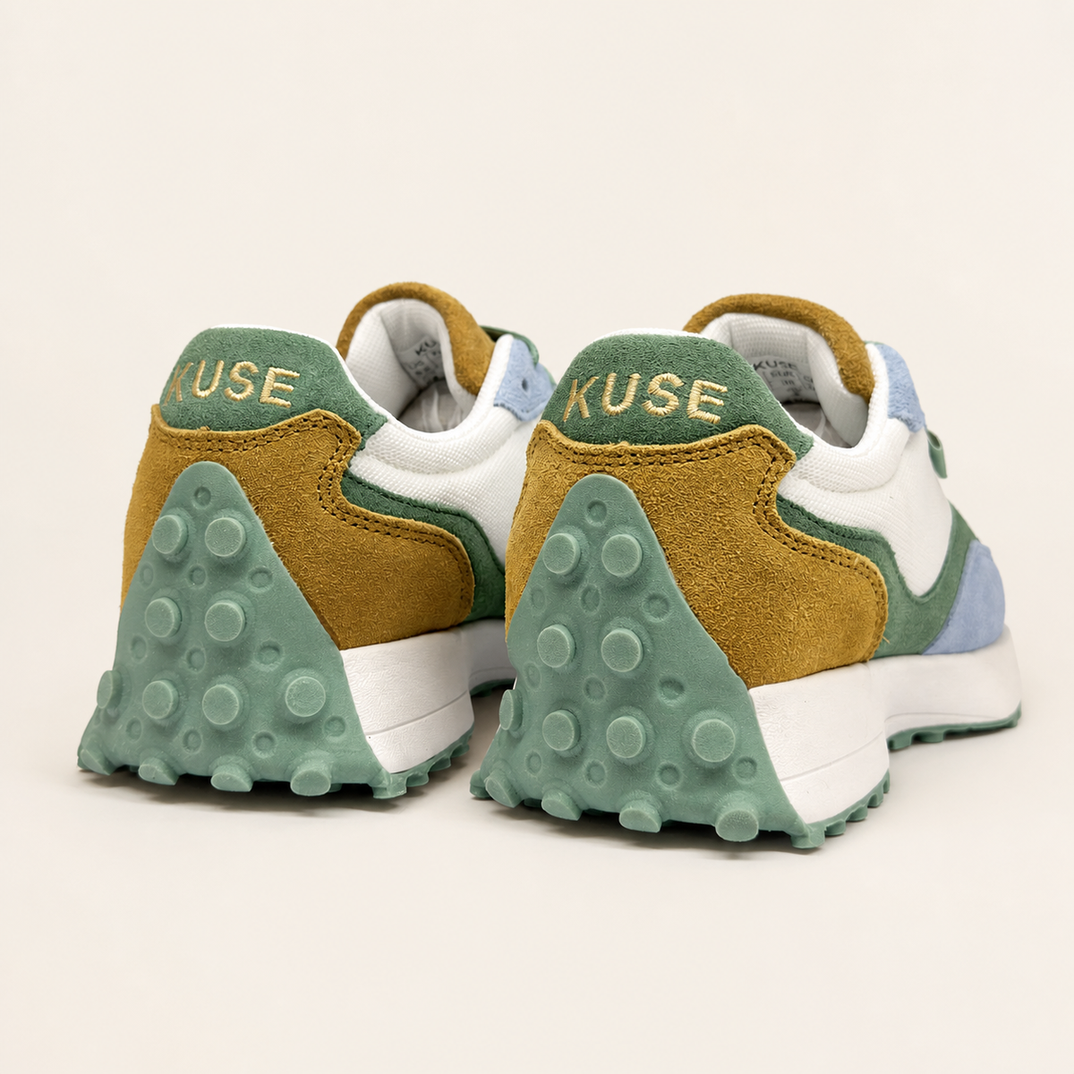 Vista trasera zapatillas casual unisex Kuse verde azul mostaza con logo bordado y suela de goma verde