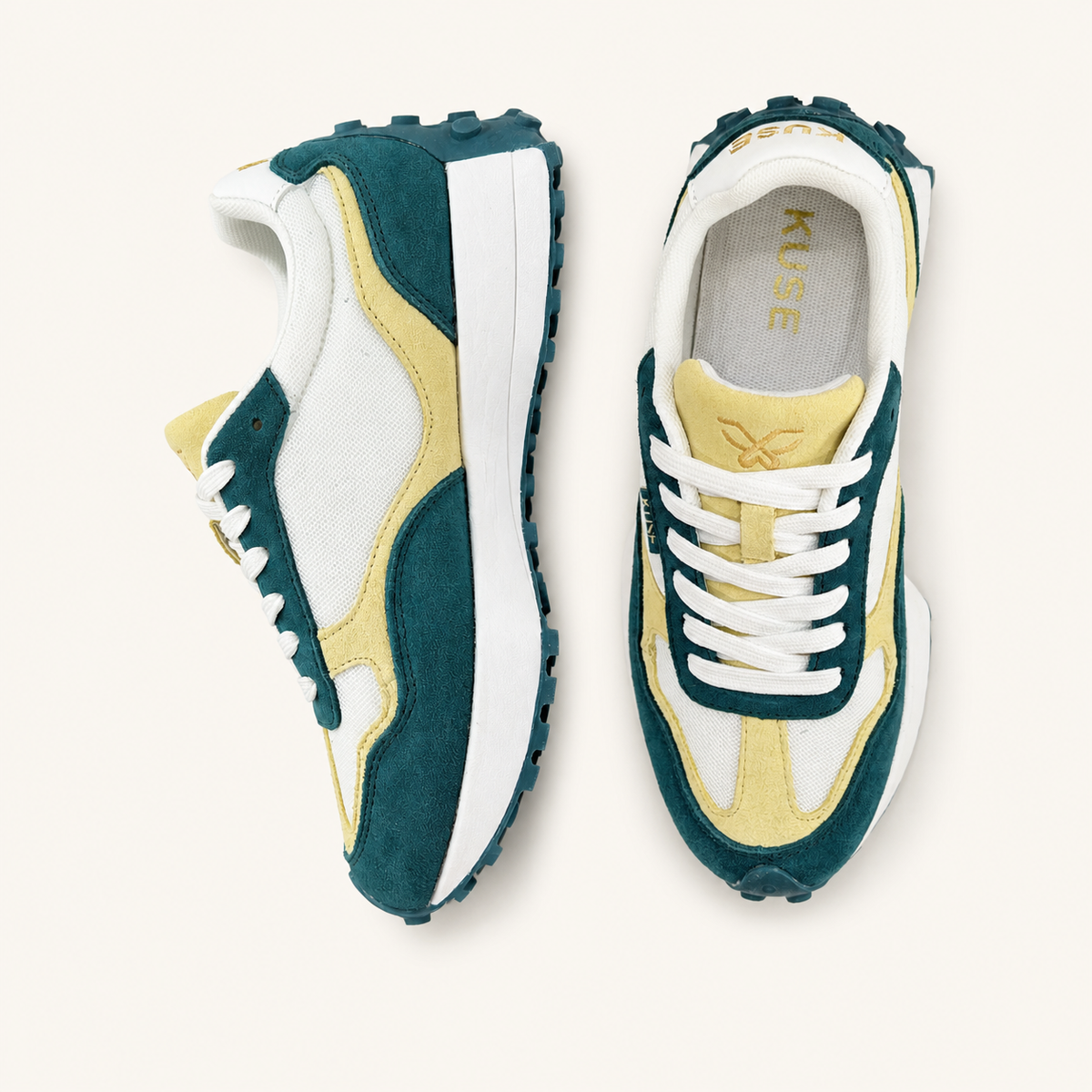 Vista superior  y lateral de zapatillas deportivas KUSE en tonos crema y verde malaquita.