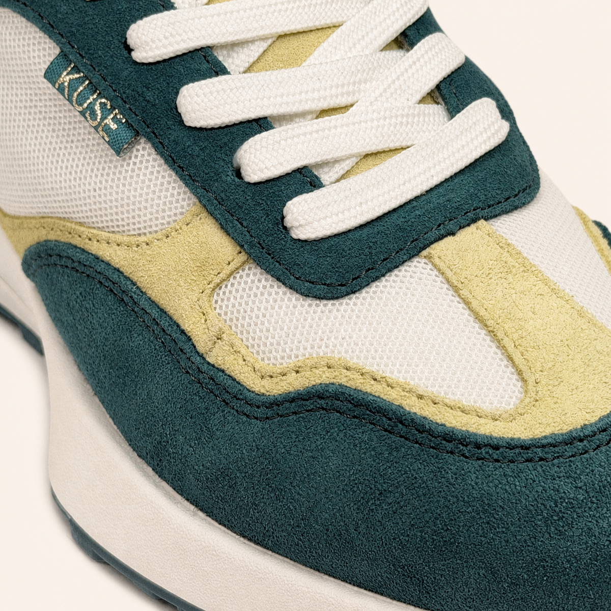 Plano detalle de zapatillas deportivas KUSE verde malaquita y crema 