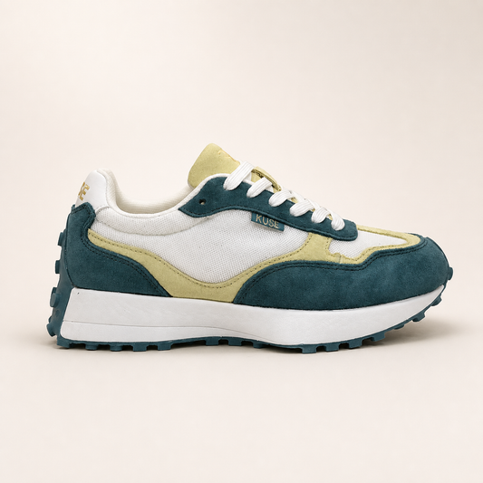 Vista lateral de zapatillas deportivas KUSE con diseño retro en verde malaquita y crema.
