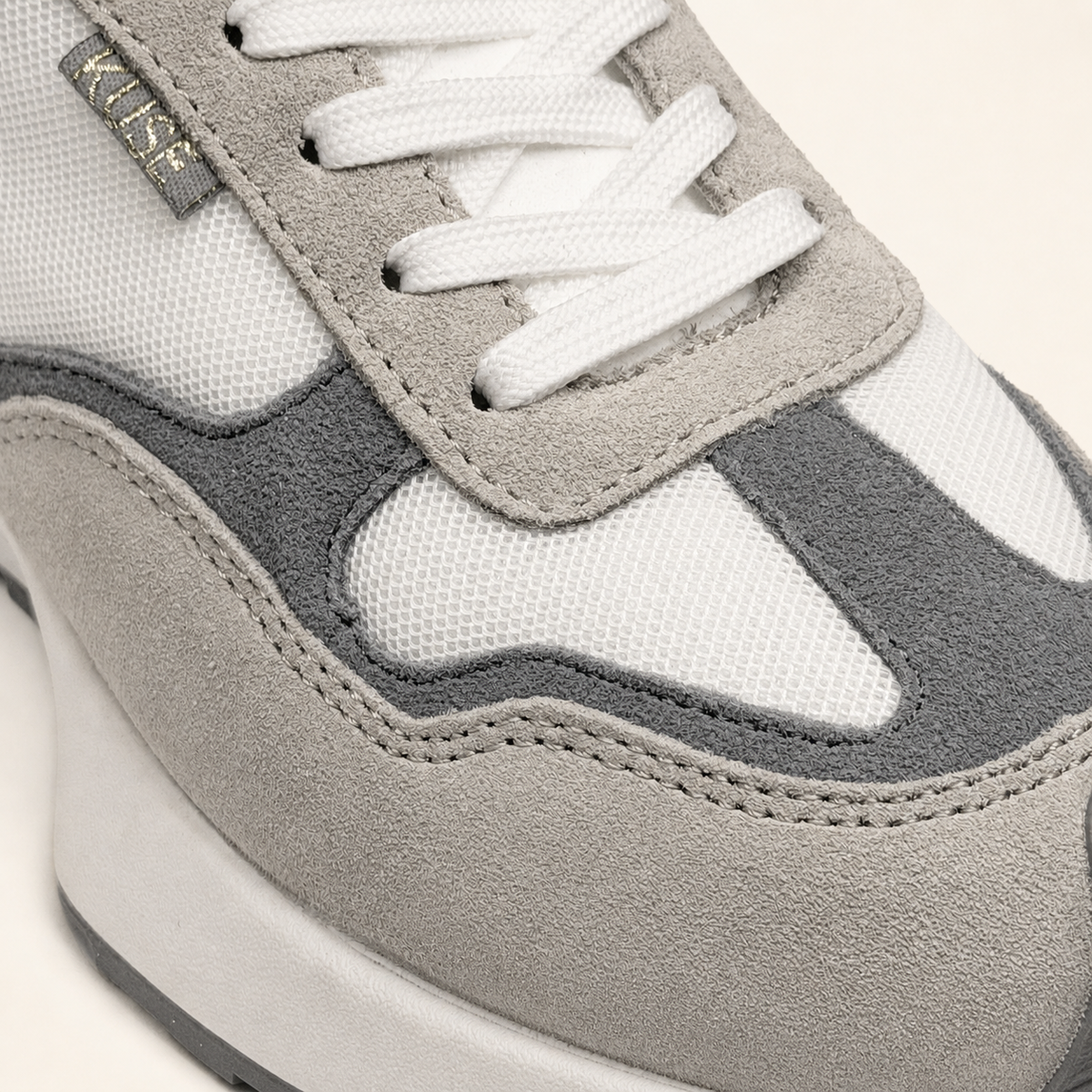 Vista detalle zapatillas Kuse unisex beige y gris con suela gruesa y acabado en serraje premium