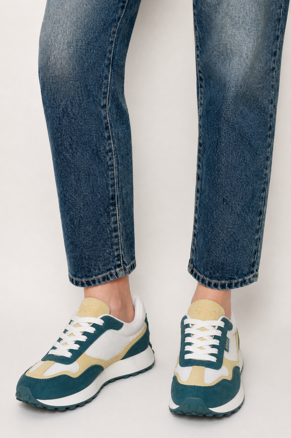 Primer plano de zapatillas deportivas KUSE para mujer en tonos verde malaquita y crema