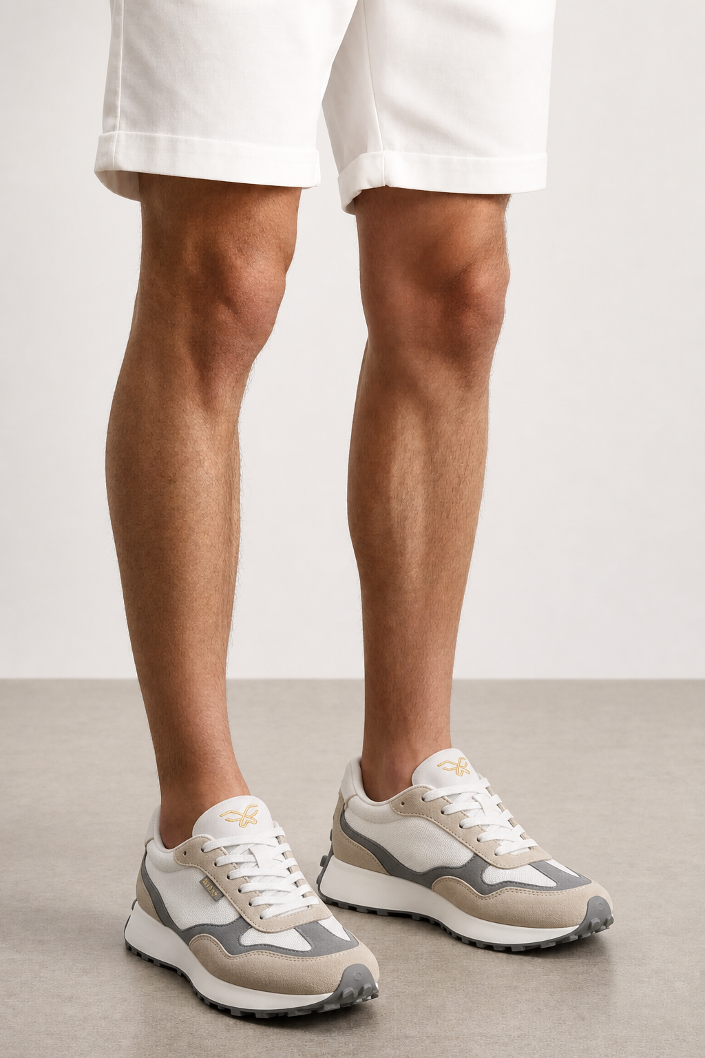 Detalle zapatillas Kuse unisex beige gris con bermudas blancas y suela dentada gris