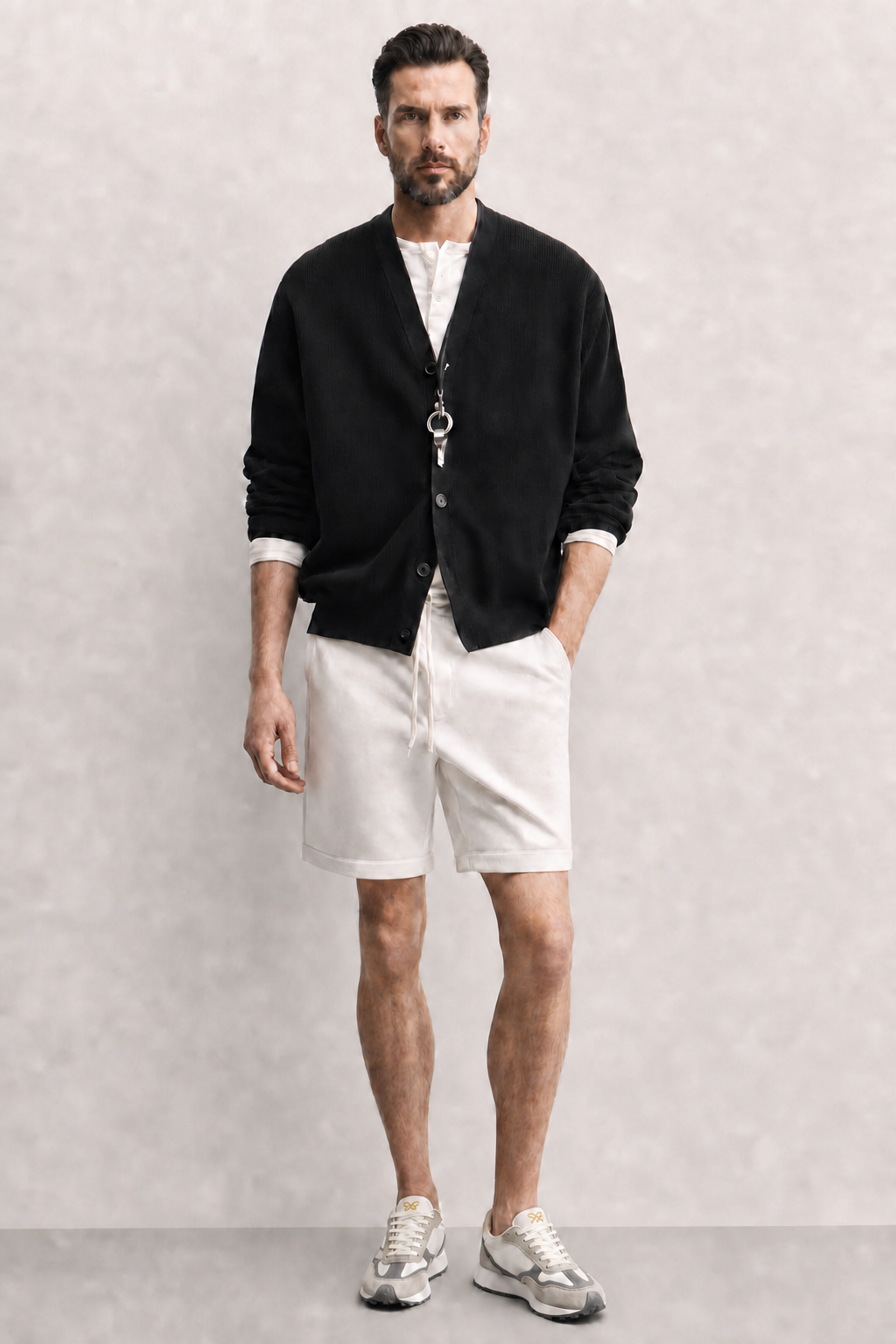 Look masculino con zapatillas casual Kuse beige y gris combinadas con bermudas blancas y chaqueta negra