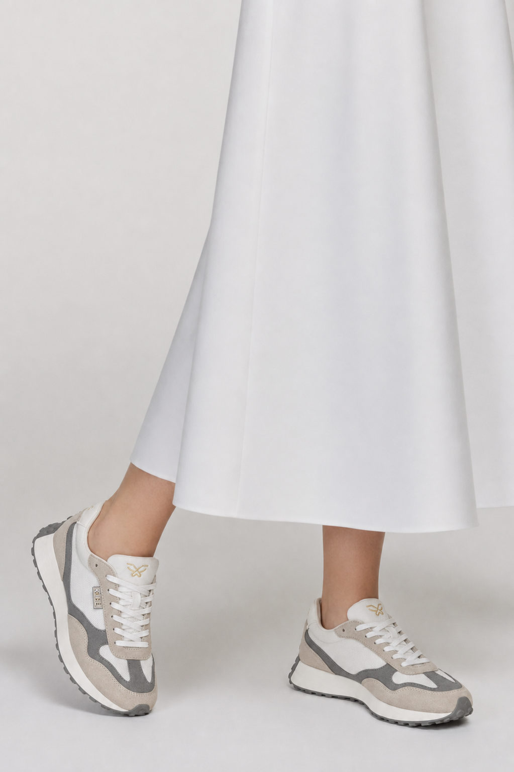Detalle outfit femenino con zapatillas Kuse beige y gris estilo urbano minimalista