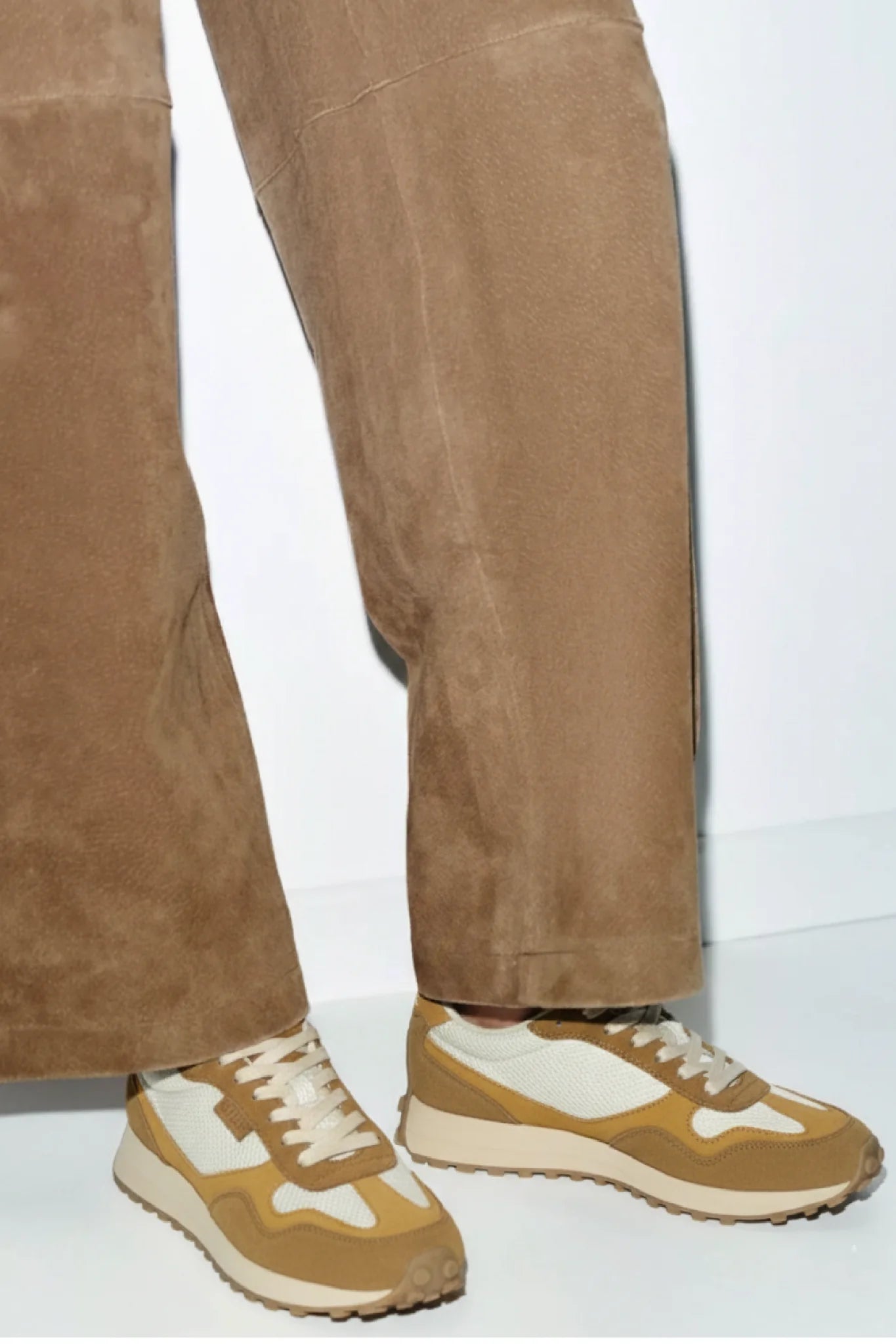 Detalle de zapatillas unisex Kuse marrones combinados con jeans doblados, estilo casual urbano moderno