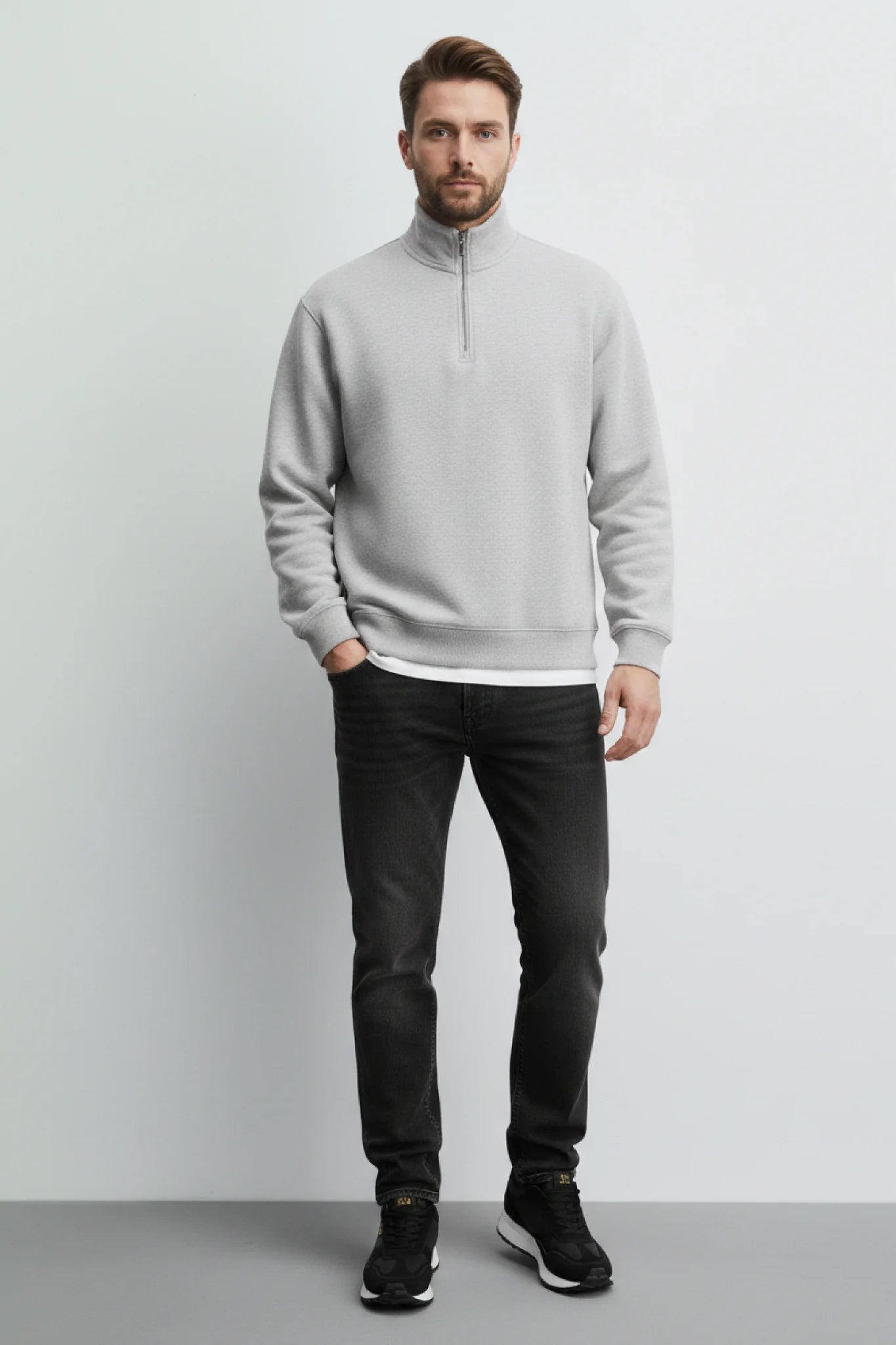Look masculino con zapatillas casual Kuse negras combinadas con jeans negros y sudadera gris minimalista