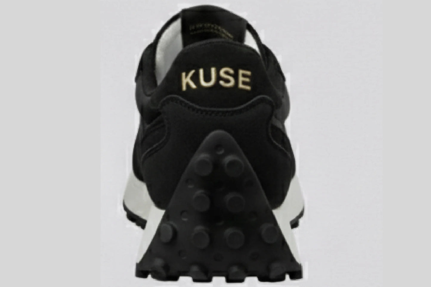 Vista trasera zapatillas casual unisex Kuse negras con logo dorado y suela de goma con tacos