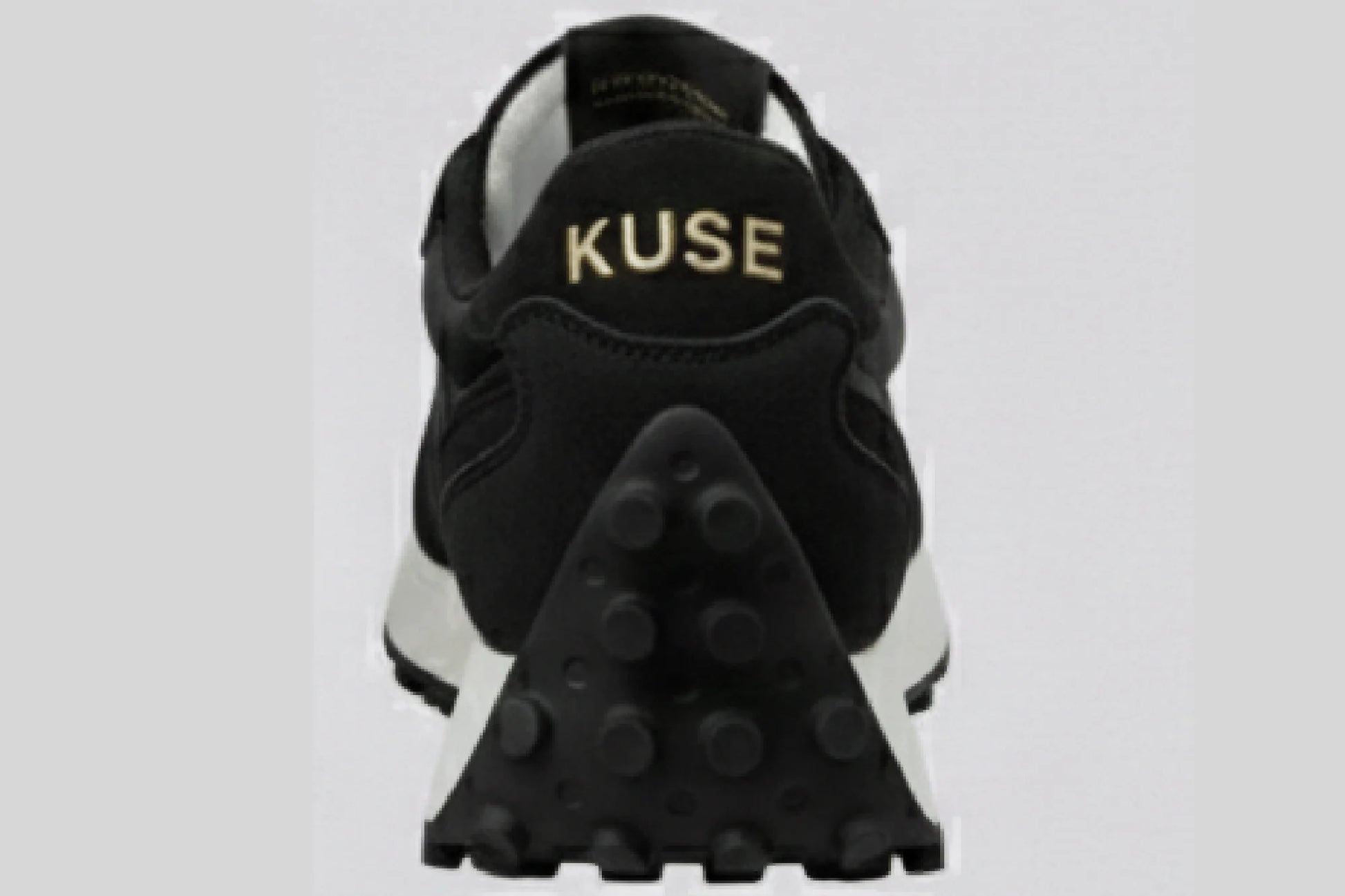 Vista trasera zapatillas casual unisex Kuse negras con logo dorado y suela de goma con tacos