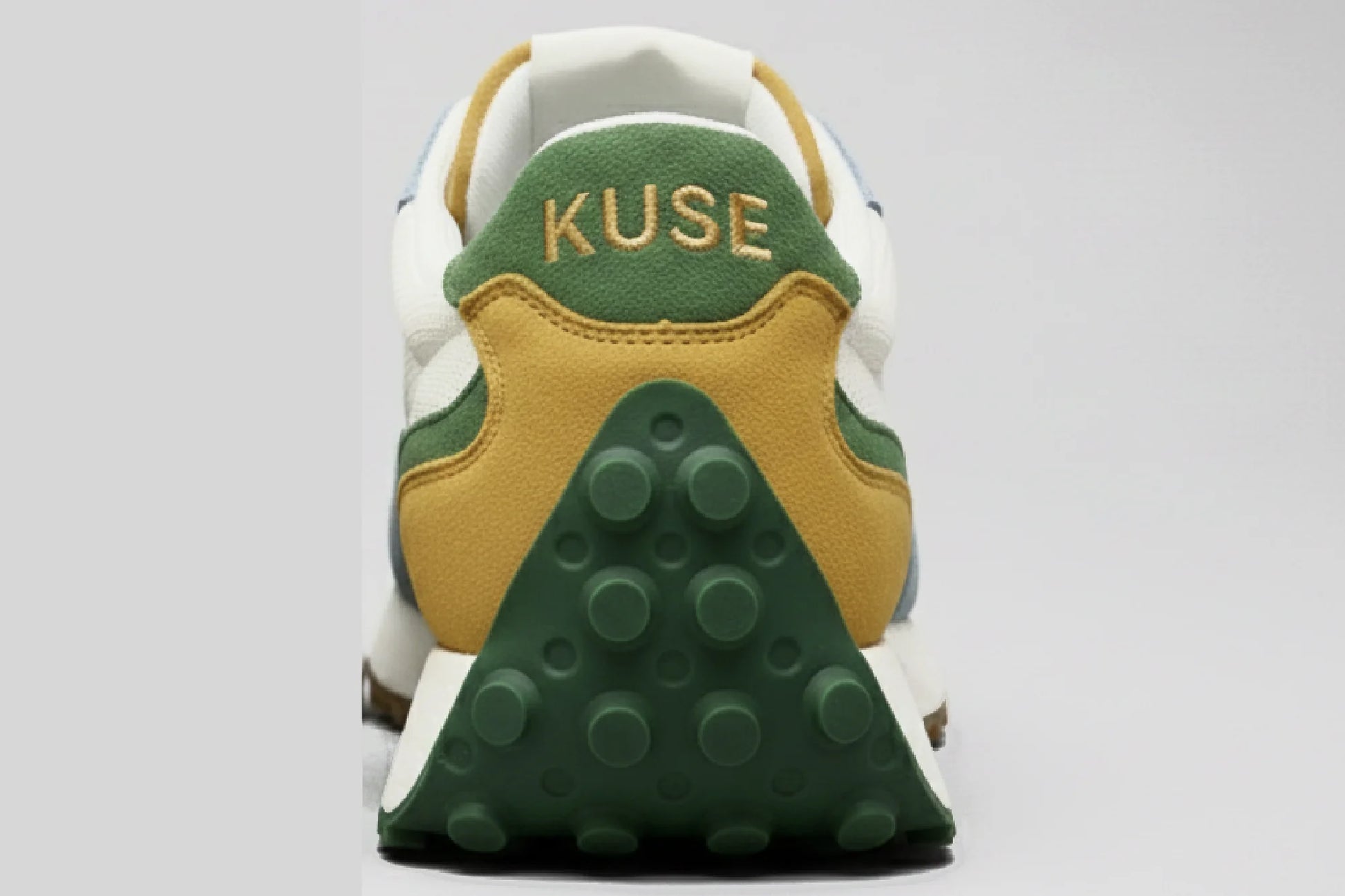 Vista trasera zapatillas casual unisex Kuse verde azul mostaza con logo bordado y suela de goma verde