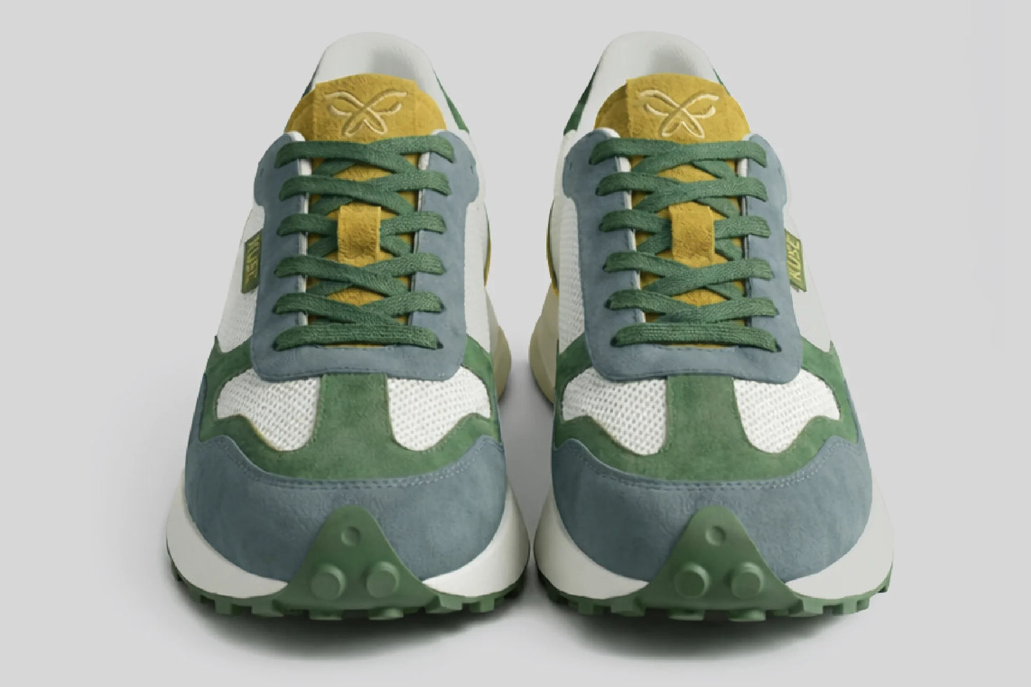 Vista frontal zapatillas casual unisex Kuse verde, azul y mostaza con cordones verdes y suela dentada