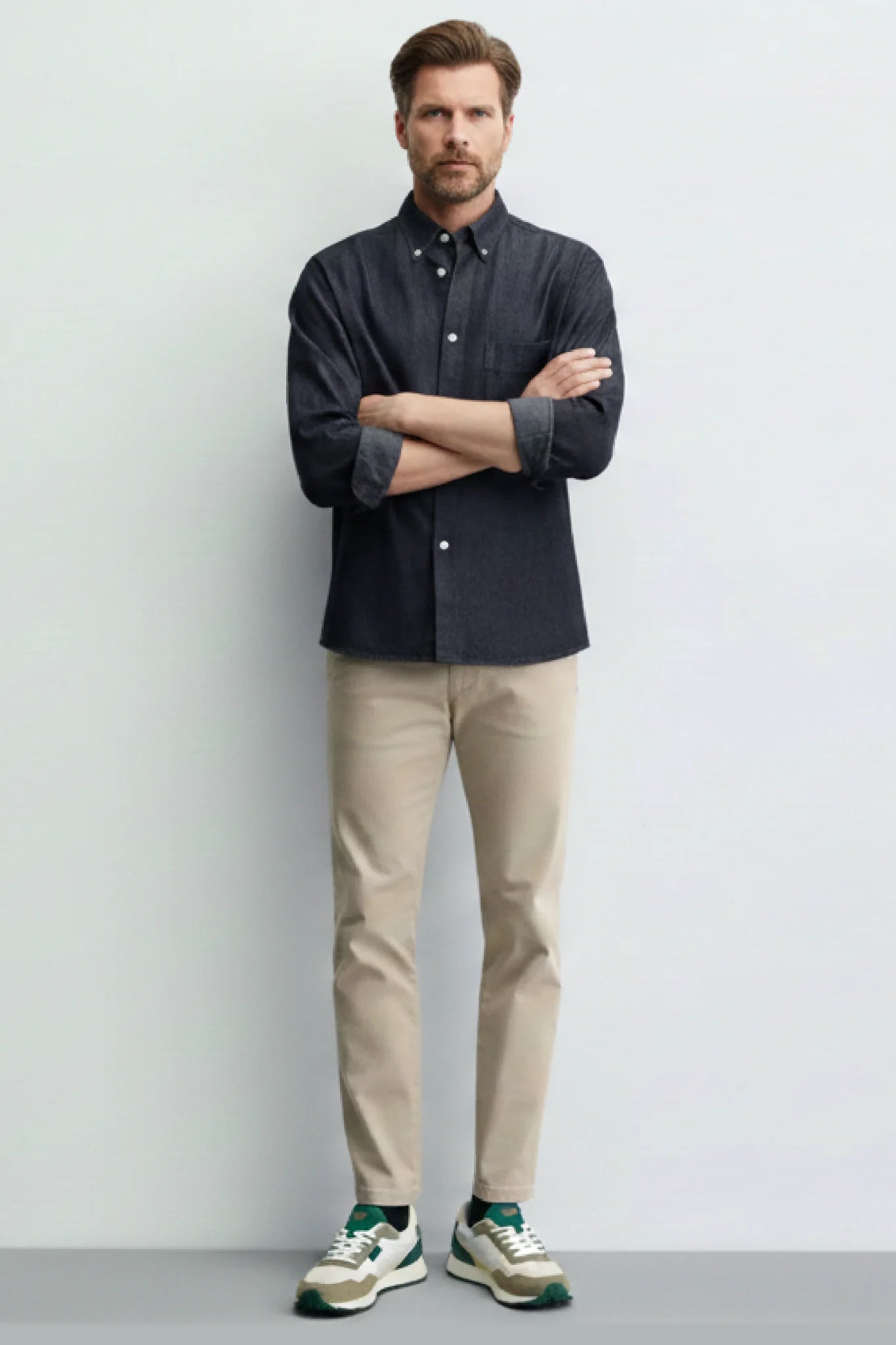 Look masculino con zapatillas casual unisex Kuse verde oliva y crema combinadas con pantalón beige y camisa oscura