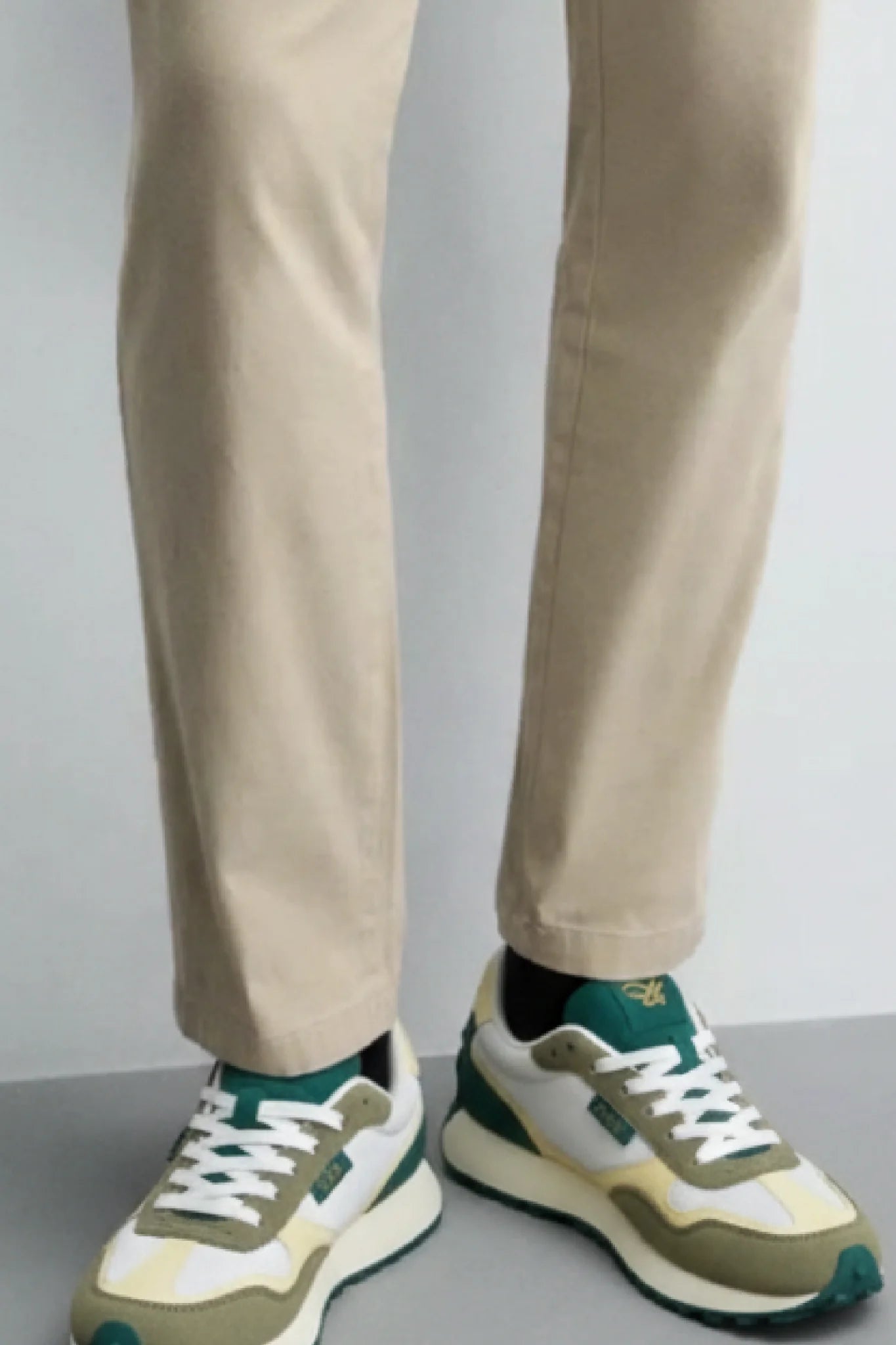Detalle outfit masculino con zapatillas Kuse verde oliva y crema estilo urbano contemporáneo