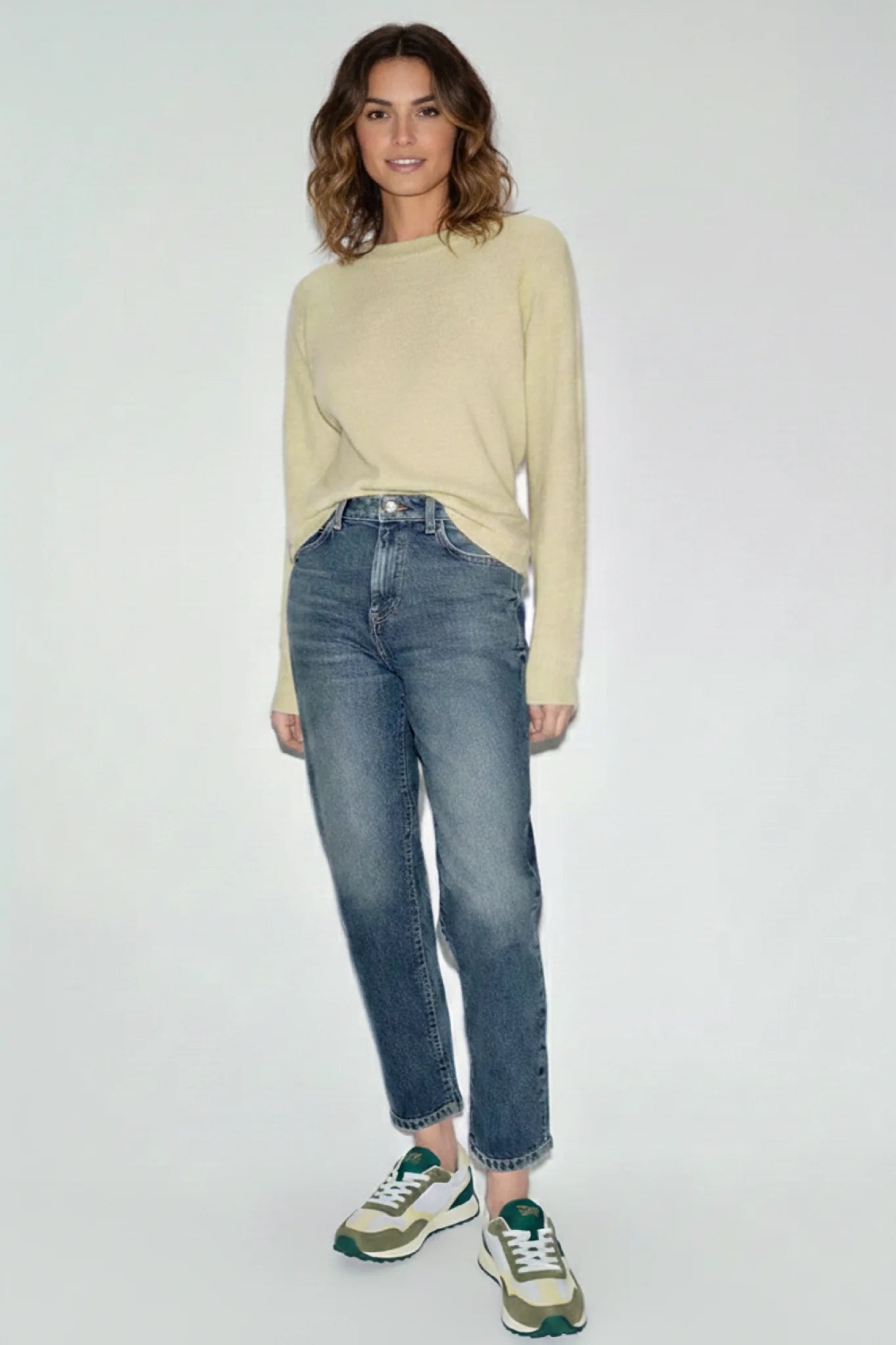 Look femenino con zapatillas casual Kuse verde oliva y crema combinadas con jeans y jersey beige